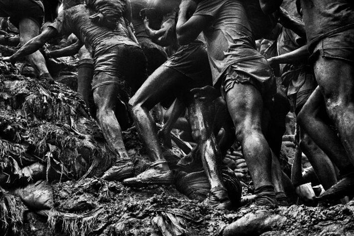 Sebastião Salgado, em 1986, captura a exaustiva jornada dos mineiros de Serra Pelada, Brasil, em meio à lama e suor, evidenciando o árduo labor sob pesos extremos e a diversidade racial, sem revelar seus rostos. Imagem do livro 'Gold - Mina de Ouro Serra Pelada', de Sebastião Salgado Foto: Sebastiao Salgado