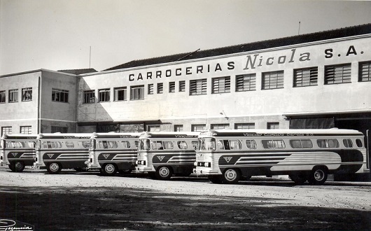 Frota de ônibus urbanos da Viação Campos Gerais, estacionados em frente à fábrica Carrocerias Nicola, em 1960. Foto: Ulysses Geremia, acervo documental da Marcopolo, divulgação