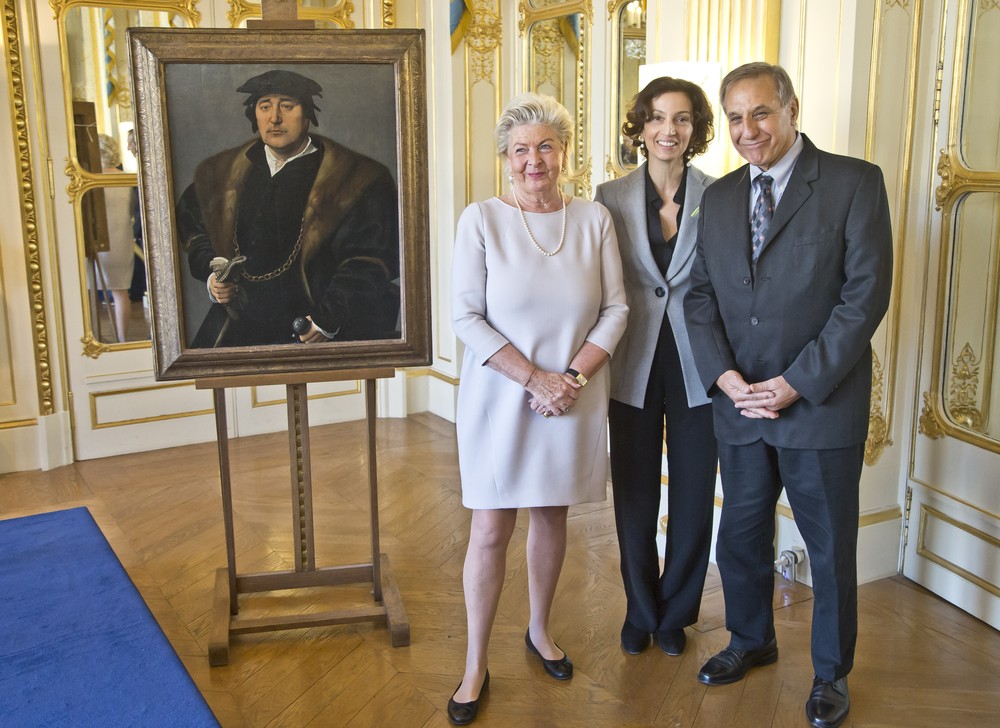 A ministra da Cultura francesa, Audrey Azoulay (centro), posa com Henrietta Schubert e Christopher Bromberg ao lado da pintura de Joos van Cleve em cerimônia no Ministério da Cultura em Paris (Foto: AP Photo/Michel Euler)