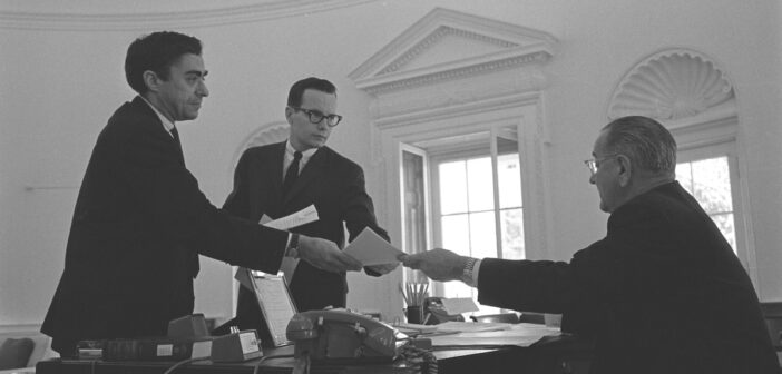 A partir da esquerda, Richard N. “Dick” Goodwin, Bill Moyers e o presidente Lyndon B. Johnson no Salão Oval em 1965. (Yoichi Okamoto/foto oficial da Casa Branca/Biblioteca LBJ)