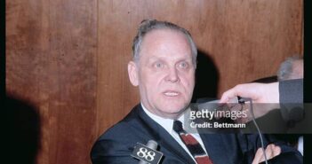 Closes de Gus Hall, Secretário Geral do Partido Comunista dos EUA, durante conferência de imprensa no Aeroporto John F. Kennedy após seu retorno de uma conferência comunista em Budapeste. (Crédito da fotografia: cortesia Bettmann Archive/ TODOS OS DIREITOS RESERVADOS)