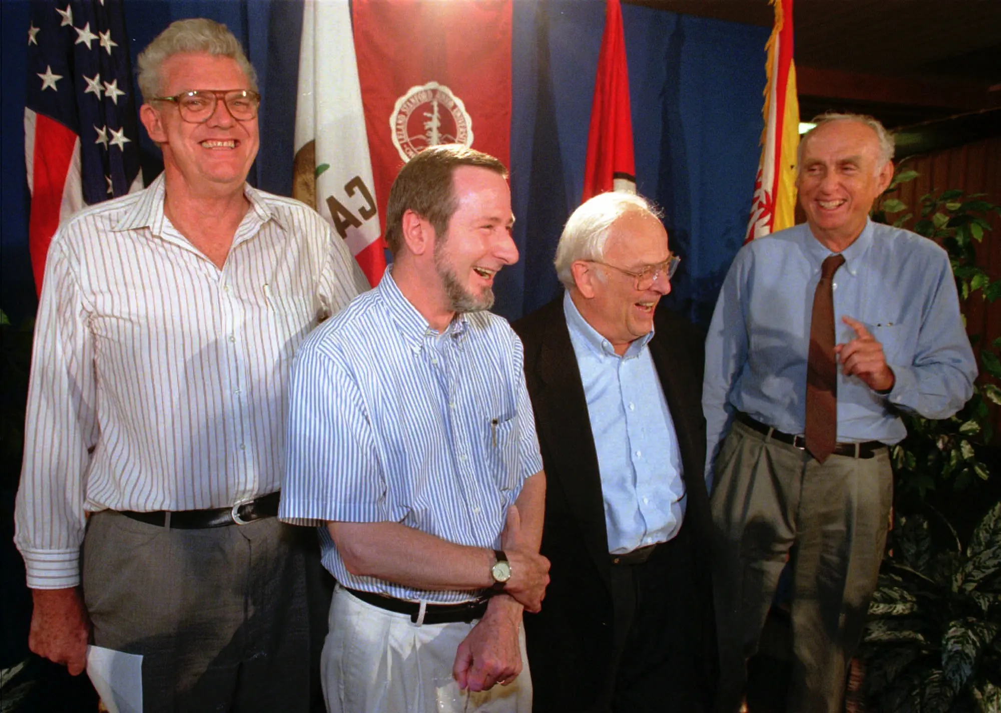 Richard E. Taylor, à esquerda, juntou-se a outros ganhadores do Prêmio Nobel da Universidade de Stanford para parabenizar um colega, Douglas Osheroff, o segundo a partir da esquerda, por ter recebido uma parte do prêmio em 1996. Com eles está Martin Perl, à direita, que compartilhou o prêmio em 1995, e Burton Richter, que o compartilhou em 1976. (Crédito da fotografia: Paul Sakuma/Associated Press)