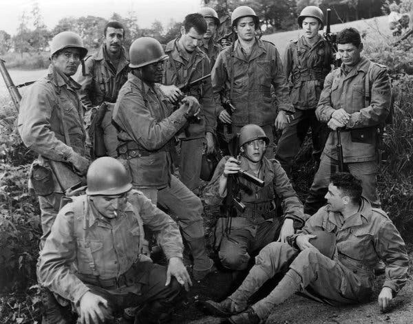 Clint Walker, de pé na extrema esquerda, em “The Dirty Dozen” (1967). Entre seus colegas de elenco: Jim Brown, de pé, terceiro da esquerda; Charles Bronson, de pé, extrema direita; e no chão, da esquerda, Telly Savalas, Donald Sutherland e John Cassavetes.Crédito...Coleção Everett