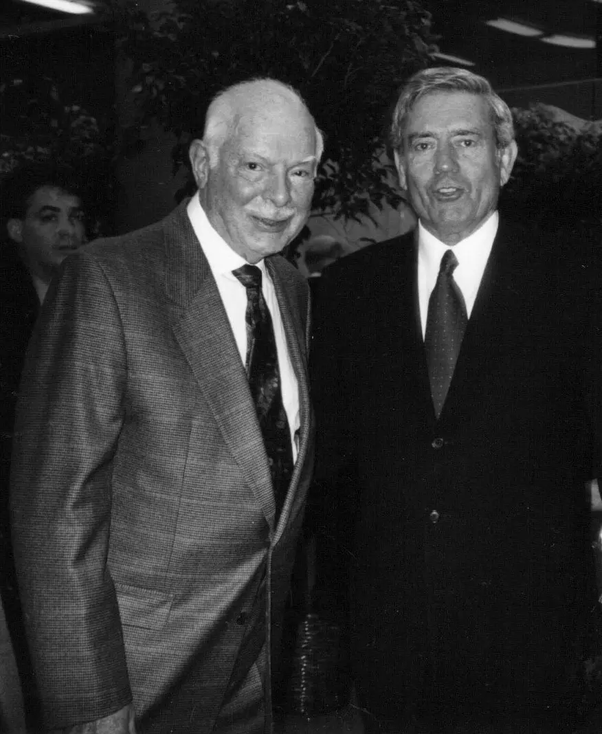 O Sr. Redmont, à esquerda, com Dan Rather na Universidade de Boston em 2000.Crédito...Joan Redmont, via Associated Press