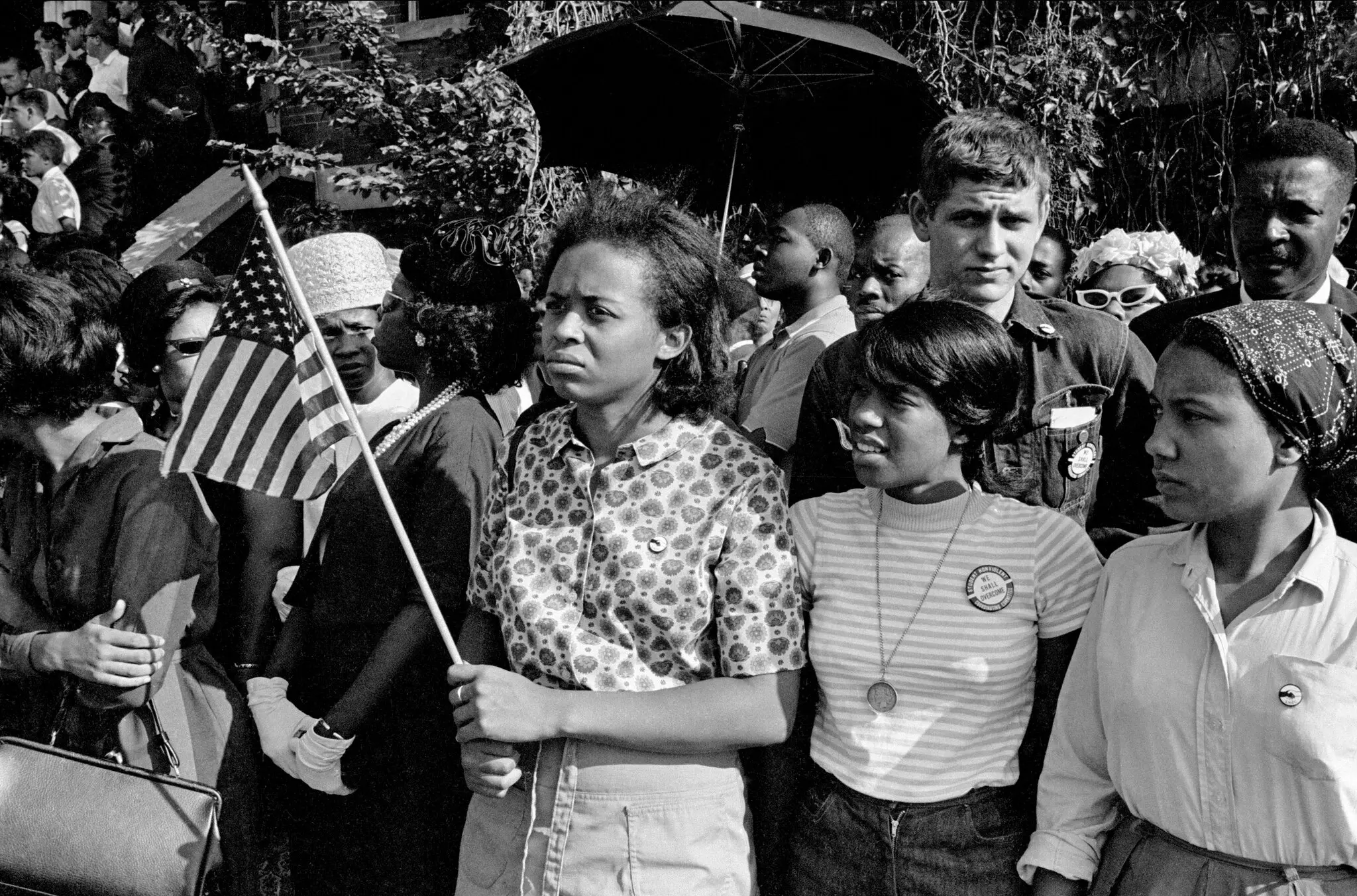 A Sra. Ladner carregava uma bandeira americana quando compareceu ao funeral das quatro meninas mortas em um atentado a bomba em uma igreja em Birmingham, Alabama, em 1963.Crédito...Danny Lyon/Fotos Magnum