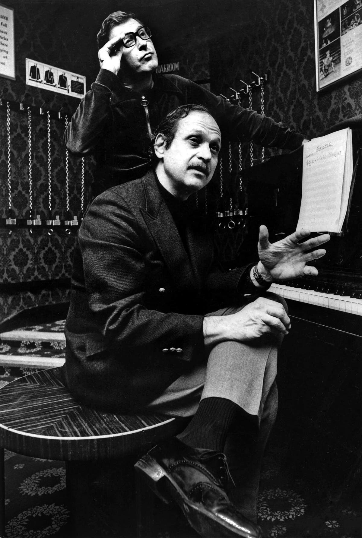 O Sr. Charles Adams, de pé, com o Sr. Strouse em 1972. Além de "Bye Bye Birdie", "Golden Boy" e "Applause", suas colaborações incluíram o tema do seriado "All in the Family".Crédito...Arquivo Bentley/Popperfoto, via Getty Images 