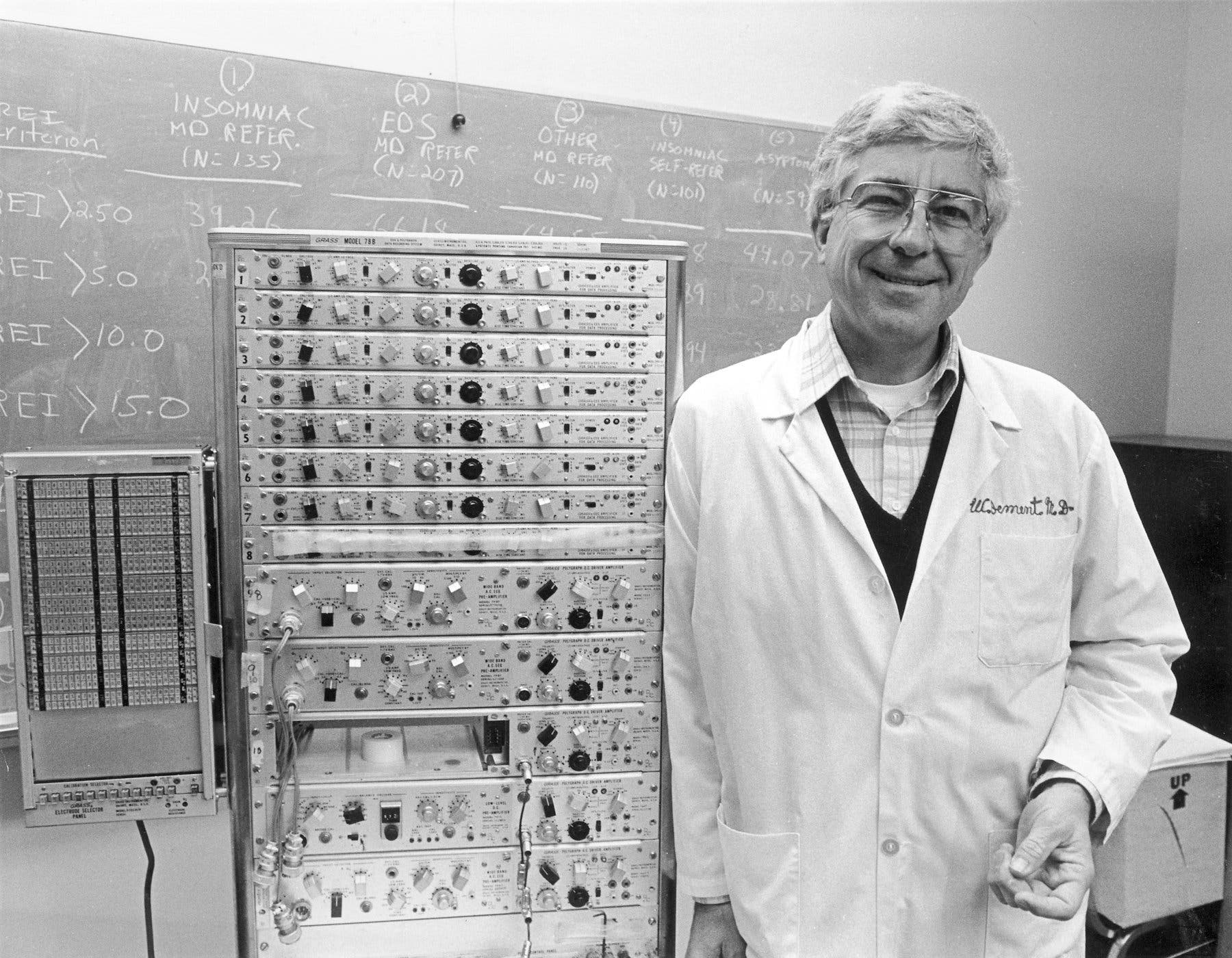 Dr. William Dement em seu laboratório de pesquisa do sono na Universidade Stanford em 1982. Ao lado dele havia um dispositivo usado para rastrear sinais elétricos emitidos durante o sono.Crédito...Ed Souza/Stanford News Service