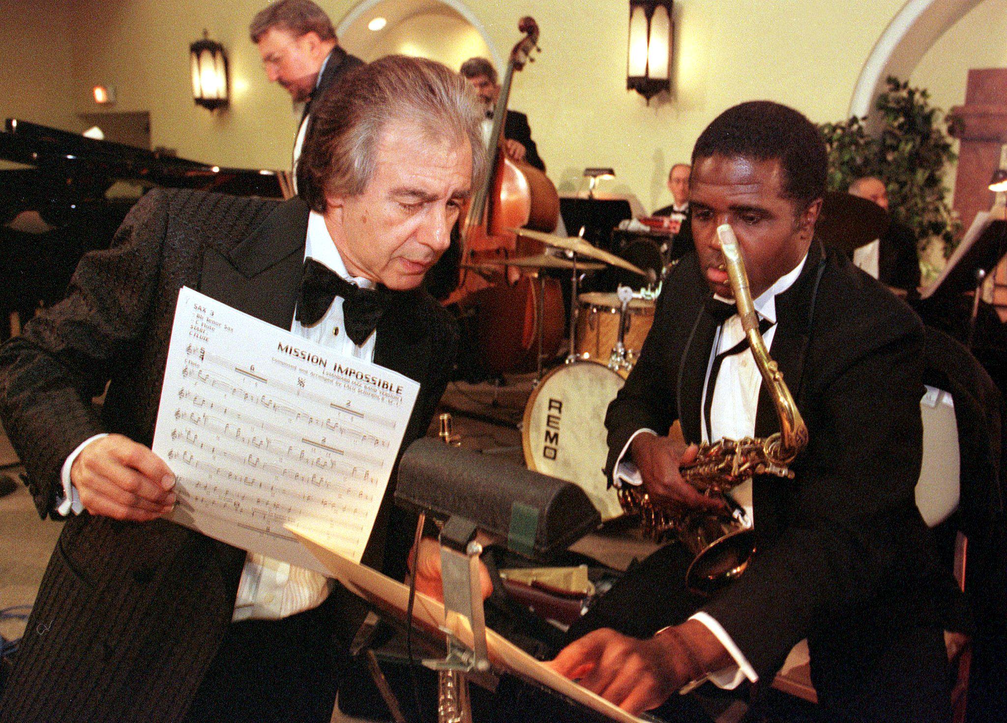 HOLLYWOOD, EUA: O compositor argentino Lalo Schifrin (E) repassa notas com um membro da Hollywood Big Band durante um ensaio antes de se apresentar em um jantar em sua homenagem com o Prêmio de Carreira da Film Music Society de 2000, em Hollywood, Califórnia. Schifrin é vencedor de vários prêmios Grammy e é mais conhecido por trilhas sonoras de filmes como Missão Impossível. FOTO AFP/Vince BUCCI (O crédito da foto deve ser Vince Bucci/AFP/Getty Images)
