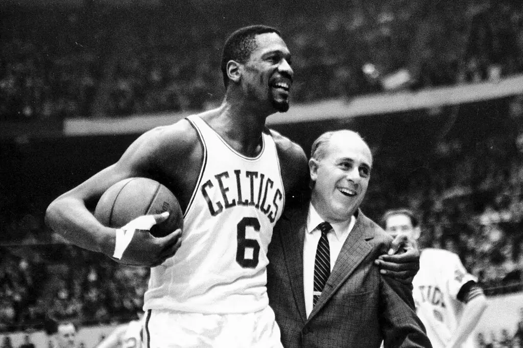 Bill Russell com seu treinador, Red Auerbach, em dezembro de 1964, após marcar seu 10.000º ponto na carreira em um jogo no Boston Garden. Em uma pesquisa de 1980 com jornalistas de basquete, ele foi eleito o maior jogador da história da NBA. (Crédito da fotografia: Cortesia © Copyright All Rights Reserved/ Associated Press ®/ REPRODUÇÃO/ TODOS OS DIREITOS RESERVADOS)