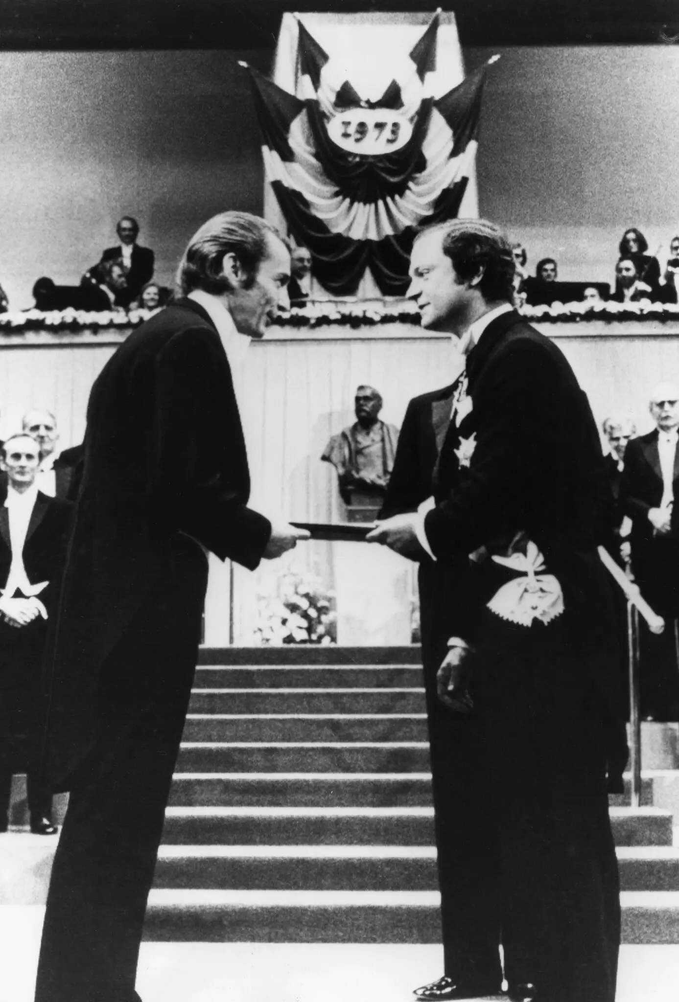 O Dr. Ivar Giaever, à esquerda, recebendo suas honras do Prêmio Nobel do Rei Carl XVI Gustaf da Suécia em uma cerimônia em Estocolmo em 1973. United Press International