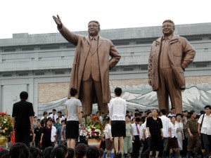 Pessoas se reúnem nas imagens de bronze dos líderes da Coreia do Norte Kim Il-sung (à esquerda) e Kim Jong-il no Mansu Hill, em Pyongyang (Foto: Jon Chol Jin/ AP)