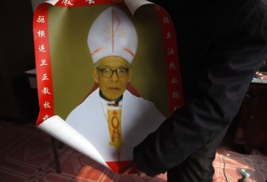 Parente do bispo católico Shi Enxiang mostra foto do religioso  em Shizhuang, na China (Foto: Greg Baker/AFP)