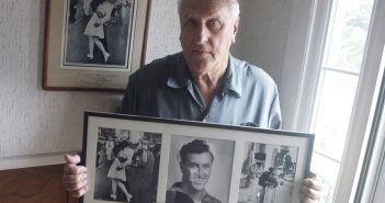In this July 2, 2009, photo George Mendonsa poses for a photo in Middletown, R.I., holding a copy of the famous Alfred Eisenstadt photo of Mendonsa kissing a woman in a nurse's uniform in Times Square on Aug. 14, 1945, while celebrating the end of World War II, left. Mendonsa died Sunday, Feb. 17, 2019, he was 95. It was years after the photo was taken that Mendonsa and Greta Zimmer Friedman, a dental assistant in a nurse’s uniform, were confirmed to be the couple. (Connie Grosch/Providence Journal via AP)