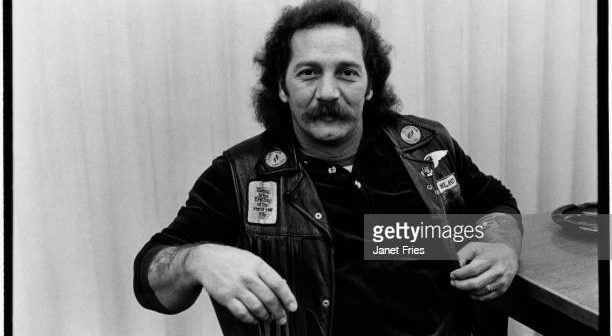Retrato do motociclista americano e membro fundador do capítulo de Oakland do Hells Angels Sonny Barger (nascido Ralph Barger) sentado em uma mesa, San Francisco, Califórnia, janeiro de 1979. (Foto de Janet Fries/Getty Images)