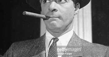 O comediante George Jessel, de chapéu e fumando charuto, parecendo indignado, na peça Show Time. (Foto de George Karger/Getty Images)