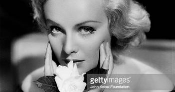 Retrato da atriz Madeleine Carroll (1906-1987) segurando uma flor, com Paramount Pictures, 1935. (Foto via John Kobal Foundation/Getty Images)
