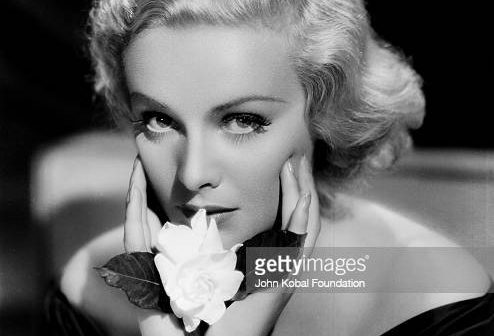 Retrato da atriz Madeleine Carroll (1906-1987) segurando uma flor, com Paramount Pictures, 1935. (Foto via John Kobal Foundation/Getty Images)