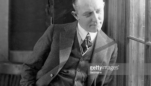 Fotografia de George M. Cohan (1878-1942) ator e dramaturgo americano e também produtor, encostado na janela. Crédito: Getty Images/ Bettmann Archive)