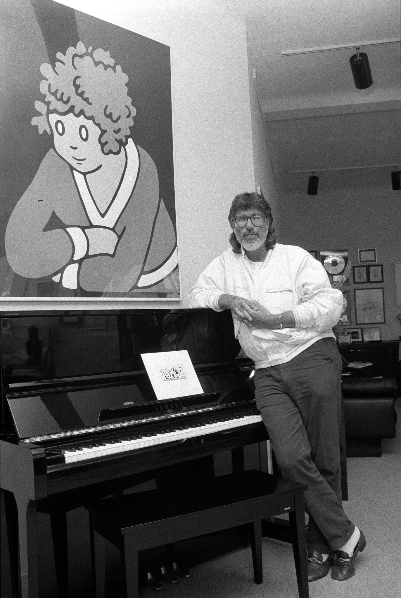 Martin Charnin em seu escritório em Manhattan em 1983. Na parede há uma pintura da pequena órfã Annie, a personagem de história em quadrinhos que inspirou “Annie”, o longa musical da Broadway que Charnin concebeu e dirigiu e para o qual escreveu a letra. (Crédito: Keith Meyers/The New York Times)