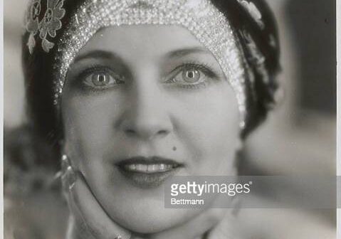 Close da atriz Olga Baclanova usando turbante bordado com strass.