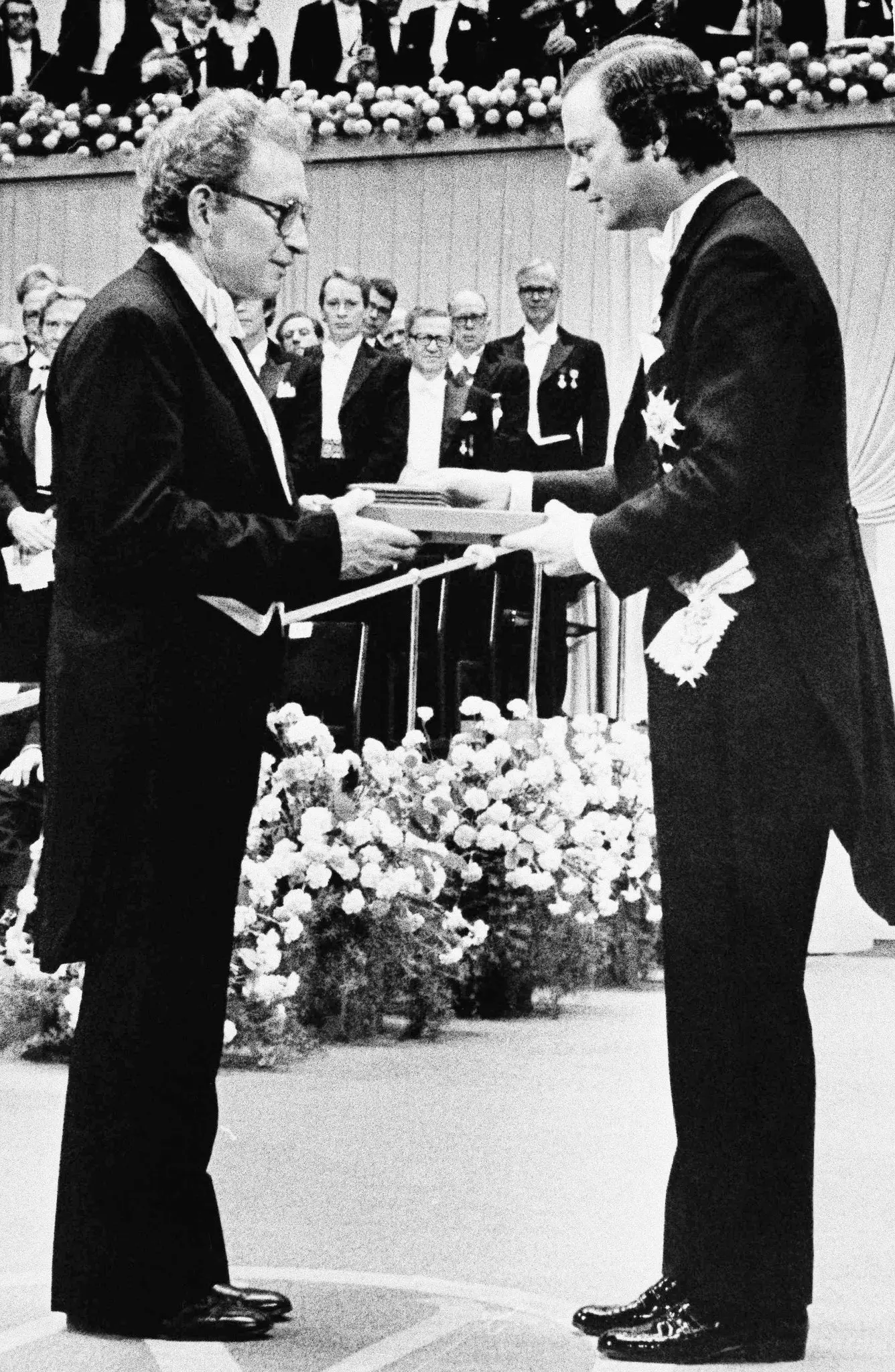 Philip Warren Anderson, à esquerda, recebeu sua parte do Prêmio Nobel do Rei Carl Gustaf da Suécia durante uma cerimônia em Estocolmo em dezembro de 1977. “Anderson foi o preeminente teórico da matéria condensada de sua época - um dia que durou mais de 50 anos. anos”, disse um colega. (Crédito da fotografia: Cortesia © Copyright Peter Knopp/Associated Press/ REPRODUÇÃO/ TODOS OS DIREITOS RESERVADOS)
