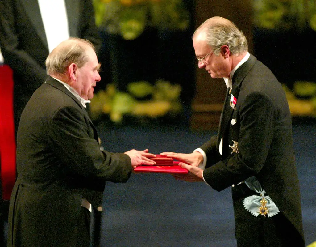 Brenner, à esquerda, recebeu o Prêmio Nobel do Rei Carl Gustaf da Suécia no Concert Hall em Estocolmo em dezembro de 2002. Dr. Brenner compartilhou-o com dois outros cientistas e acreditou que merecia um segundo Nobel, por seu trabalho na decodificação do ADN. (Crédito da fotografia: Henrik Montgomery, via Associated Press)