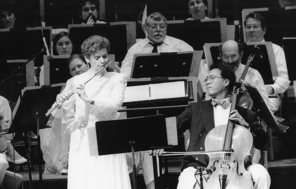 No topo, Doriot Anthony Dwyer tocou com a Orquestra Sinfônica de Boston por 38 anos como seu flautista principal. Acima, Dwyer e Yo-Yo Ma tocaram 'Variations on an Octatonic Scale' de Leonard Bernstein em 1995.Crédito...Walter Scott/Orquestra Sinfônica de Boston