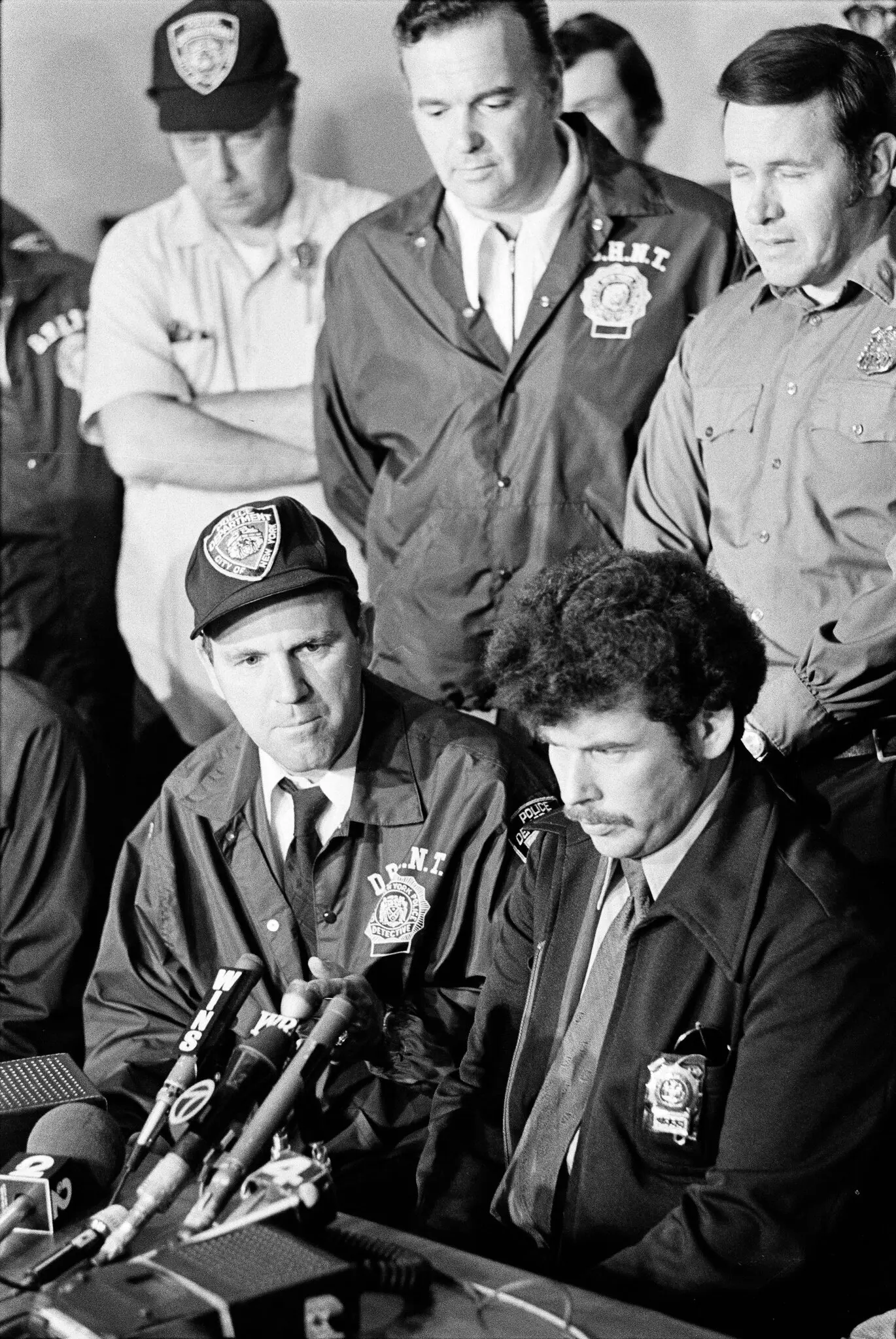 Dr. Schlossberg, sentado à direita, discutindo um caso em 1974 em que uma menina foi resgatada de uma situação de refém. Ao lado dele estava Frank Bolz, tenente da Divisão de Detetives. Bolz tornou-se comandante de uma equipe de negociação de reféns e o Dr. Schlossberg, seu estrategista.Crédito...Paul Hosefros/The New York Times