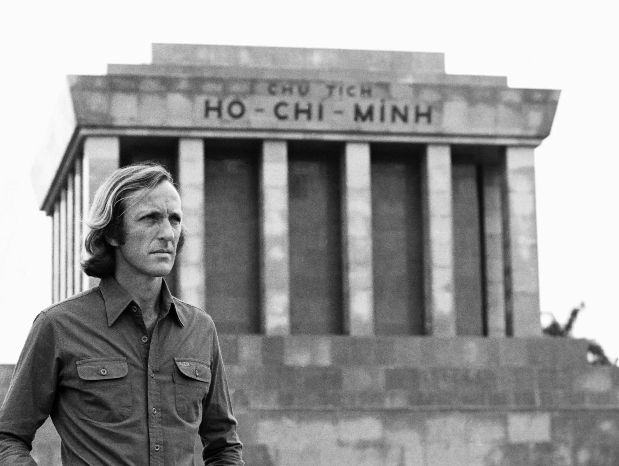 John Pilger em 1979 no Mausoléu de Ho Chi Minh em Hanói, Vietnã. Seus muitos filmes feitos no Sudeste Asiático foram elogiados, mas ele também foi acusado de subordinar o jornalismo à defesa de direitos. (Crédito da fotografia: Coleção Hulton-Deutsch/Corbis, via Getty Images)