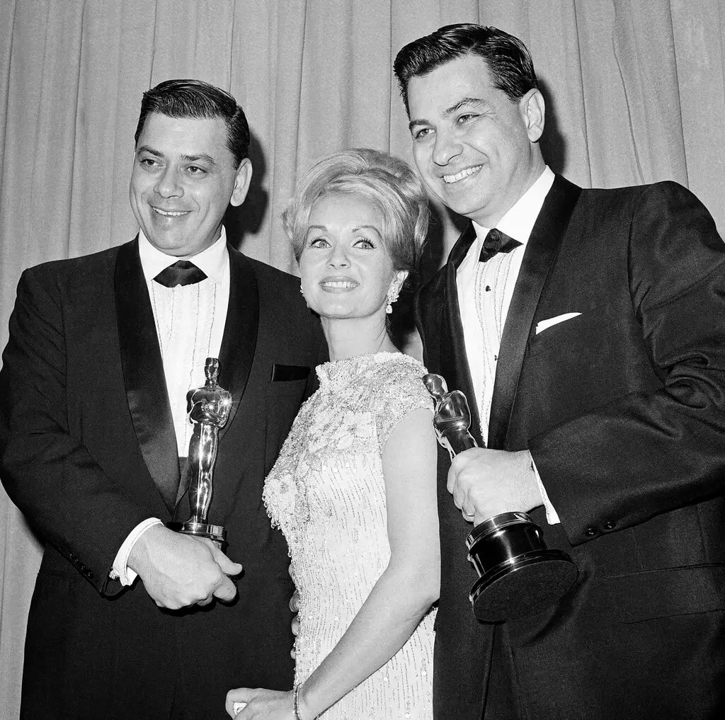 Richard M. Sherman, à direita, e seu irmão, Robert, com Debbie Reynolds no Oscar de 1965, onde os Shermans ganharam duas vezes por sua música para "Mary Poppins". Os irmãos também escreveram as canções para "The Jungle Book" e muitos outros filmes da Walt Disney. (Crédito da fotografia: Cortesia Imprensa associada)