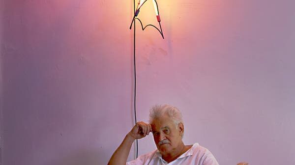 Keith Sonnier em 2012 com “Kada” (2009), de sua série de obras murais Oldowan. Ele incorporou objetos funcionais do cotidiano, como lonas para velas, à sua arte.Crédito...Jason Schmidt/Galeria Pace