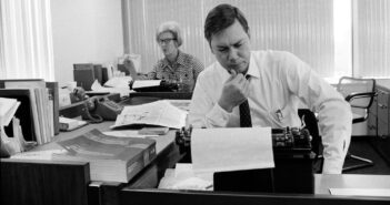 Roy Reed no escritório de Washington do The New York Times em 1968. Ao fundo está Marjorie Hunter, uma repórter do Times. (Crédito da fotografia: Cortesia George Tames/The New York Times)