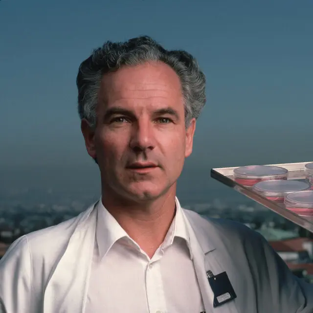 Peter H. Duesberg em 1985, segurando uma bandeja de placas de Petri contendo células cancerígenas cultivadas. No final da década de 1960, ele descobriu o primeiro gene causador de câncer conhecido, ou oncogene.Crédito...Roger Ressmeyer/Corbis — VCG, via Getty Images